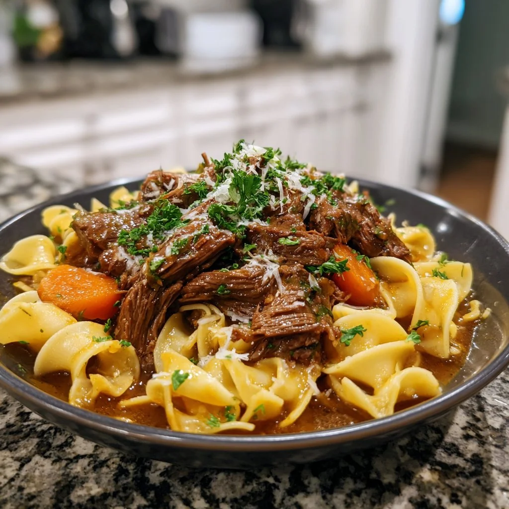 Cozy slow cooker beef and noodles served in a bowl with fresh herbs.