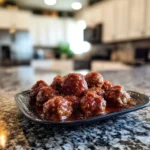 Slow cooker honey garlic meatballs served on a plate with sauce and garnish.