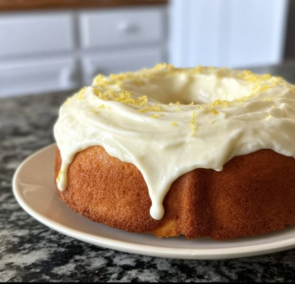 Lemon cake with lemon cream cheese frosting served on a white plate