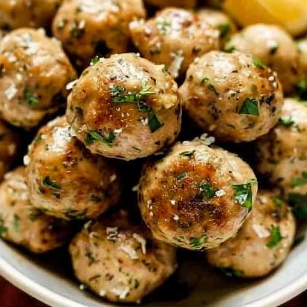 Delicious baked chicken meatballs served on a plate with herbs and sauce.